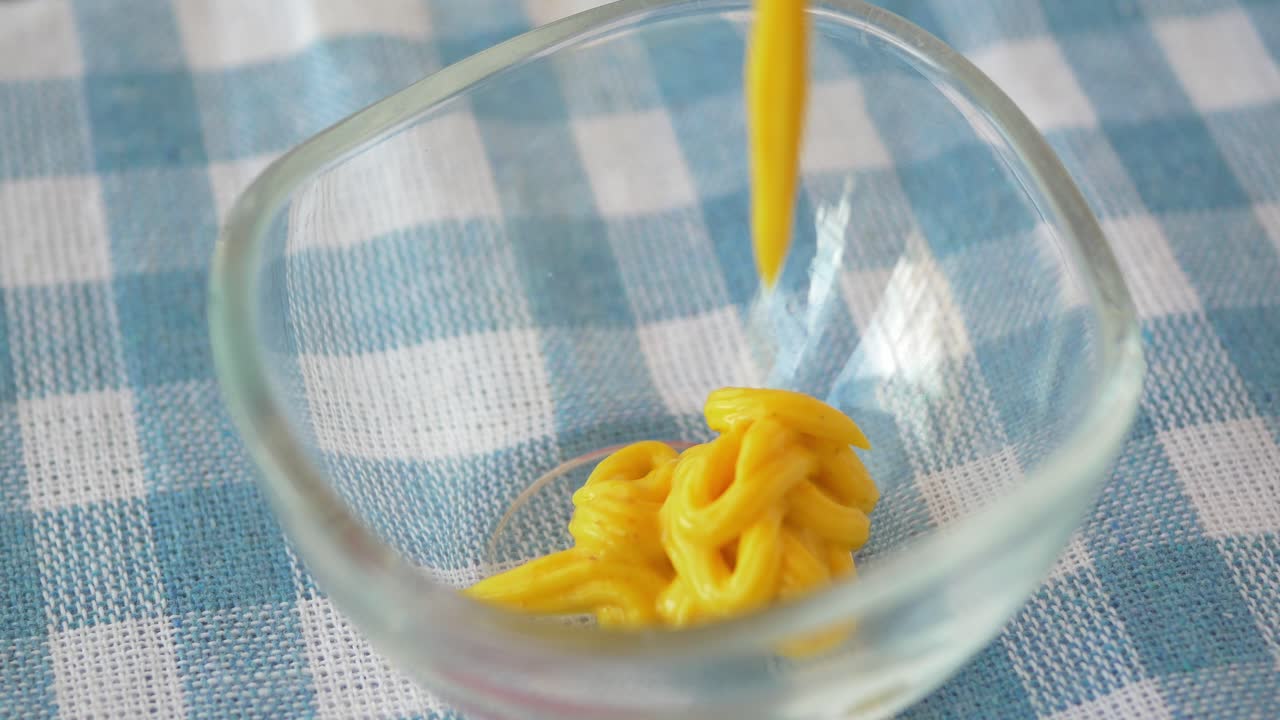 Mustard being poured into a bowl