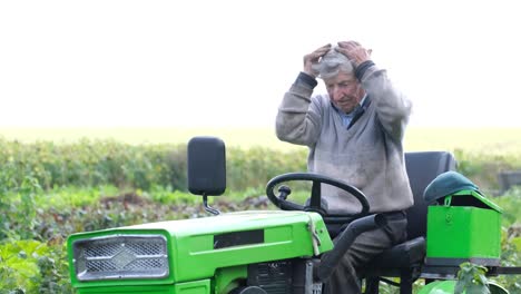 A farmer on a green tractor in a field