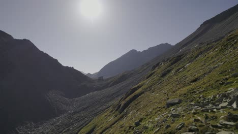 Die-Drohne-Fängt-Zwei-Wanderer-Auf-Einem-Wanderweg-In-Der-Nähe-Der-Edelrauthütte-Oder-Des-Rifugio-Passo-Ponte-Di-Ghiaccio-Ein,-Eingetaucht-In-Die-Warmen-Farben-Der-Goldenen-Stunde