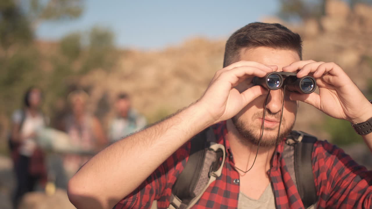 Group of friends exploring nature with binoculars and map