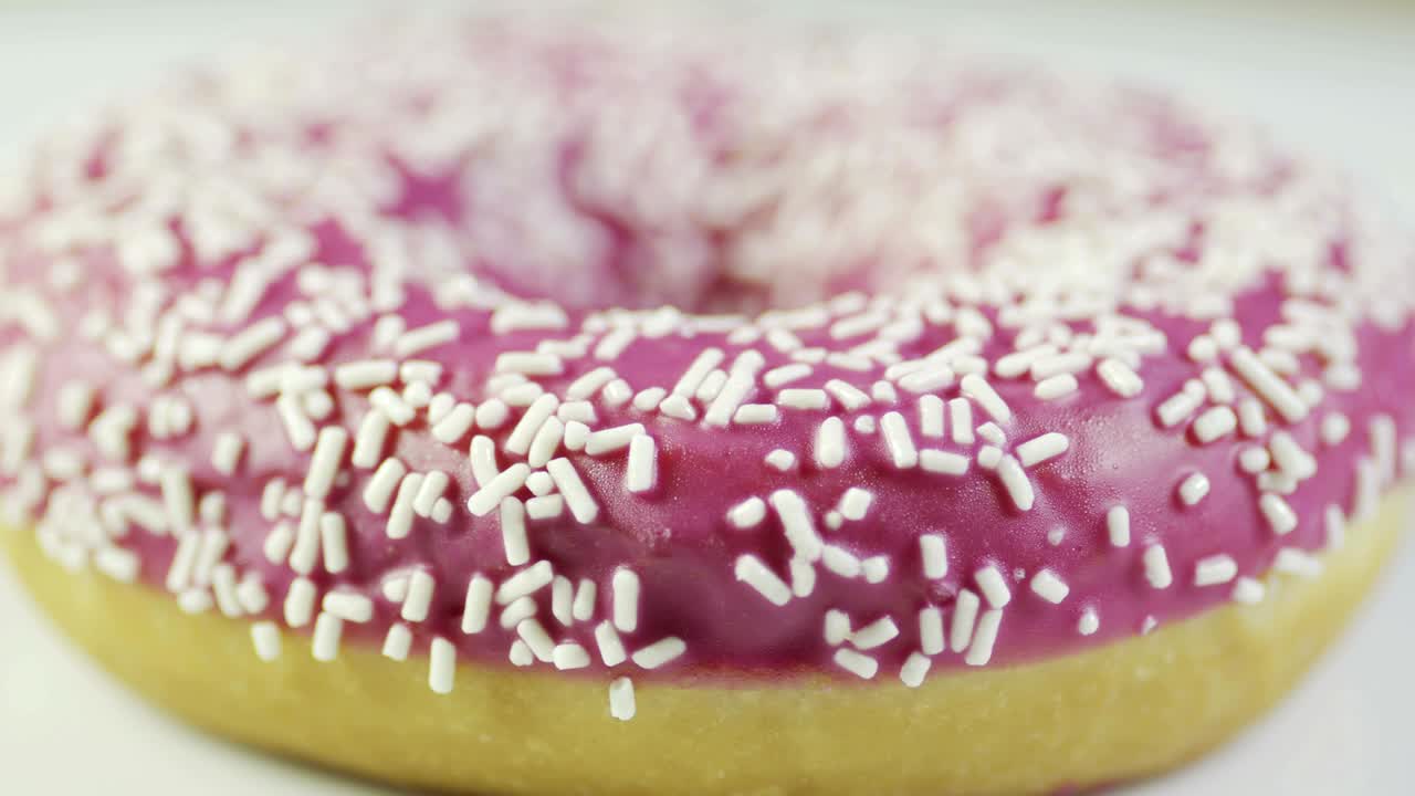 rosquillas recubiertas de frambuesa girando en la mesa