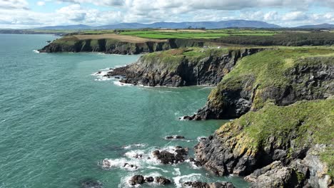 Drohnenküste-Irlands,-Felsige-Landzungen,-Meereshöhlen-An-Der-Kupferküste-Von-Waterford-Am-Letzten-Sommertag