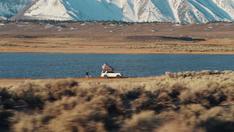 lone adventure person setting up campsite with roof top tent at mammoth lakes