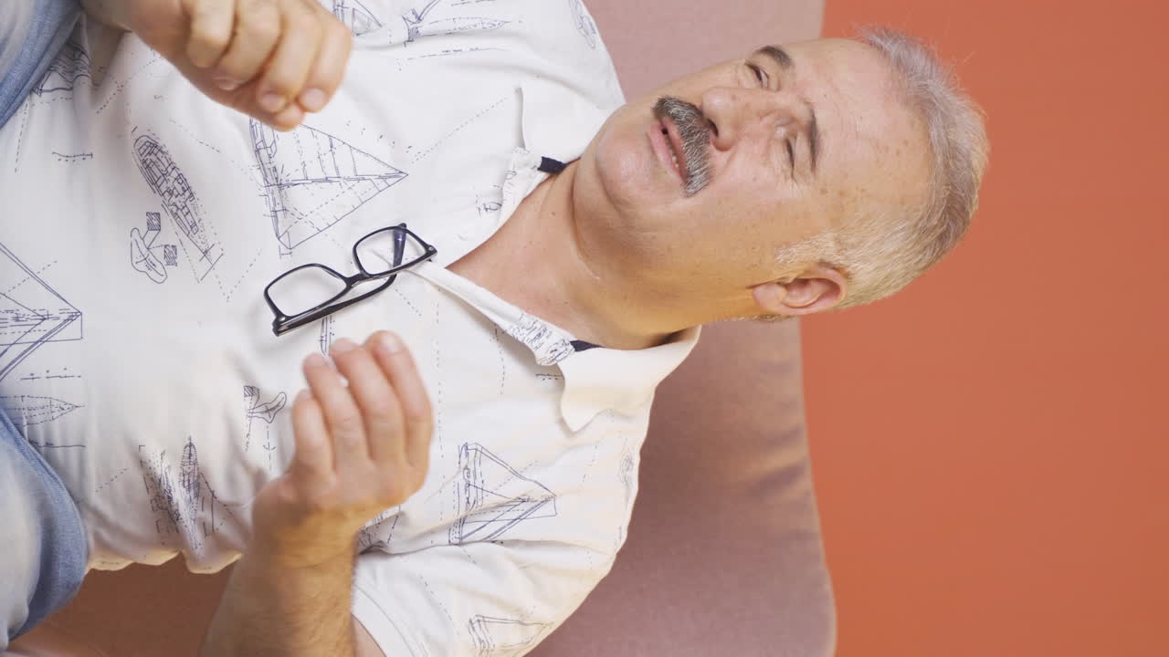 video vertical de un anciano con picazón en las orejas.