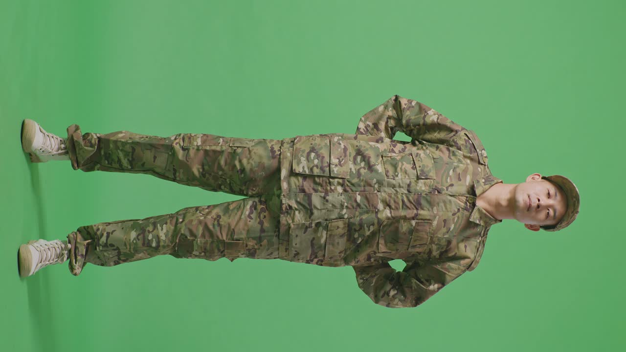 Full Body Of Asian Army Soldier Standing Against On Green Screen Background Studio. Brave Young Servicemen Wearing Camouflage Military Uniform