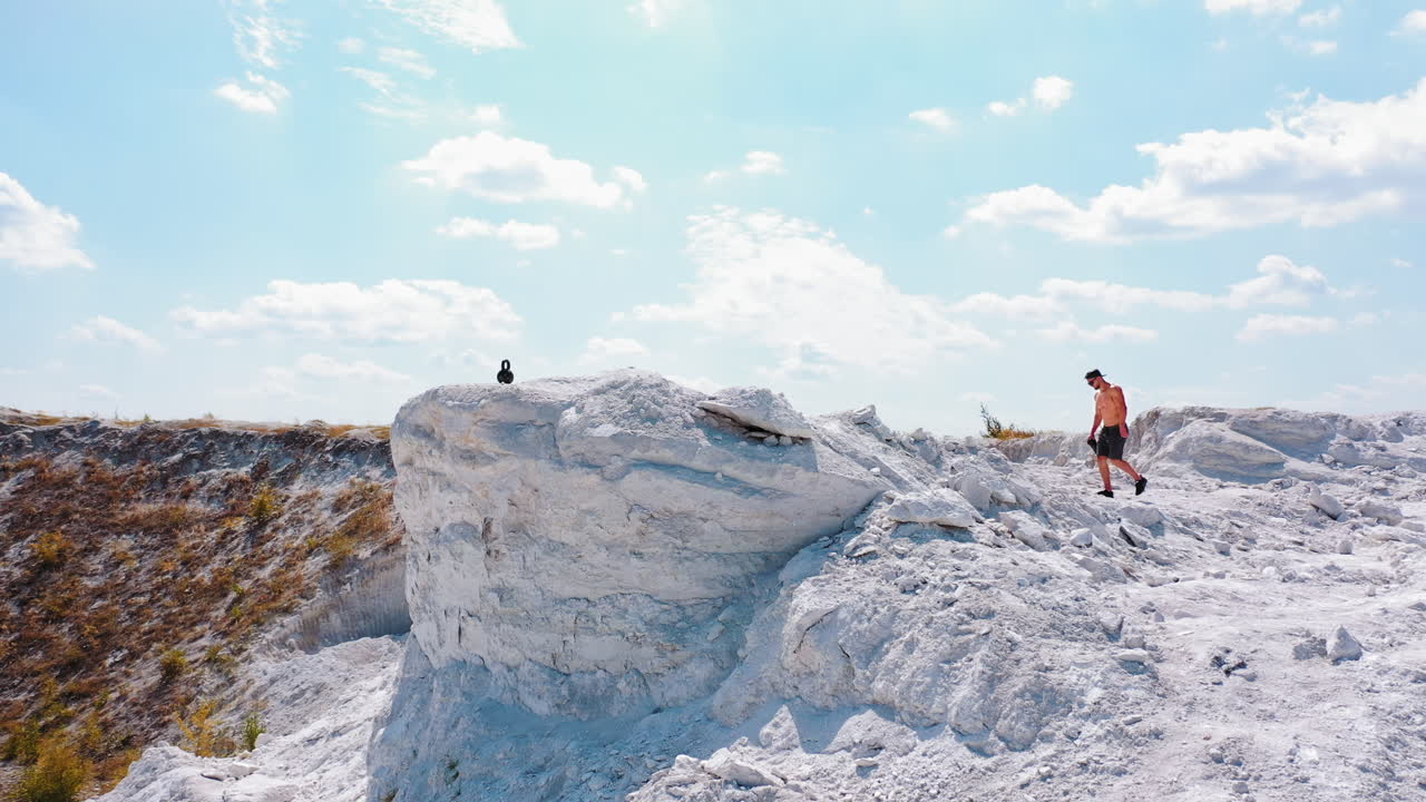Man Resting After Workout. Aerial view of athletic man resting after hard training in the mountains