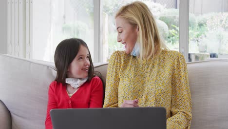 mother and daughter having a video chat on laptop at home