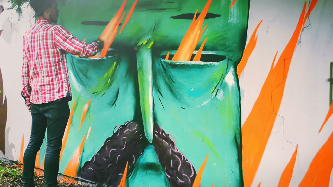 L'artista disegna graffiti su una recinzione. Graffiti su una recinzione.