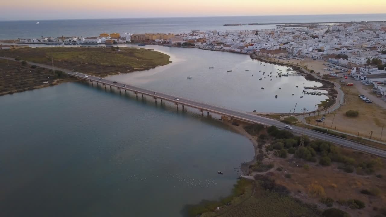 Aerial view of the Barbate river reaching the sea and a bridge over it.