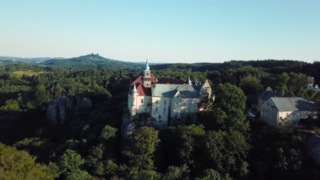Chateau-Hruba-Skala-in-Bohemian-Paradise,-Czech-Republic,-Trosky-castle-in-the-distance,-Drone-view---orbiting-and-fly-up,-4k-or-UHD,-30fps