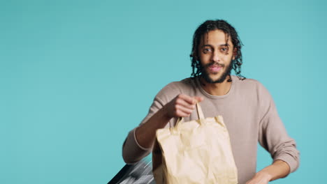 friendly delivery employee taking takeaway lunchbag out of thermal bag, studio