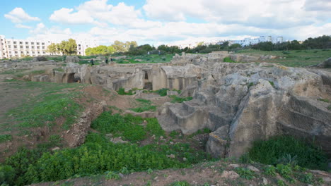 wide landscape shot of the tombs of the kings, showcasing the extensive archaeological site with its historic ruins and natural setting