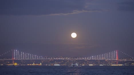 full moon over the bosphorus bridge at night