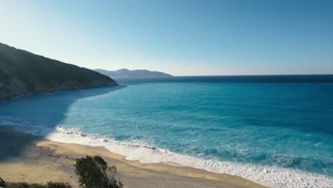 beautiful long beach on an island with stunning blue-colored sea and waves