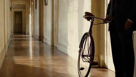 person with a vintage bicycle in a sunlit hallway