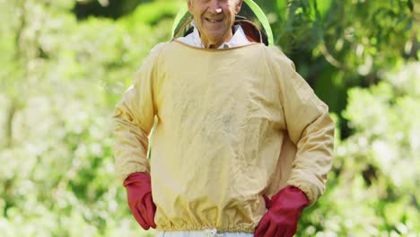 retrato de un apicultor caucásico sonriente con ropa de protección