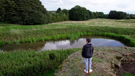 Aerial-video-footage-of-a-young-boy-looking-out-on-the-the-remains-of-Bolingbroke-Castle