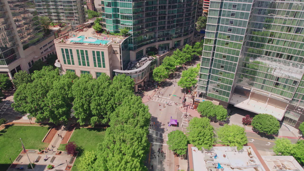 Et storslått flyfoto som nærmer seg Peachtree Street dekket av trær under en Streets Alive urbanisme-event i Atlanta, med syklister og fotgjengere som nyter en lys sommerdag i byen Georgia