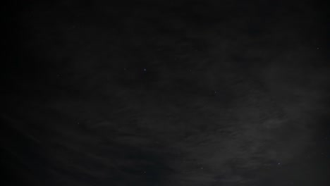 Time-Lapse-of-clouds-rolling-by-to-reveal-a-starry-night,-wide-4K