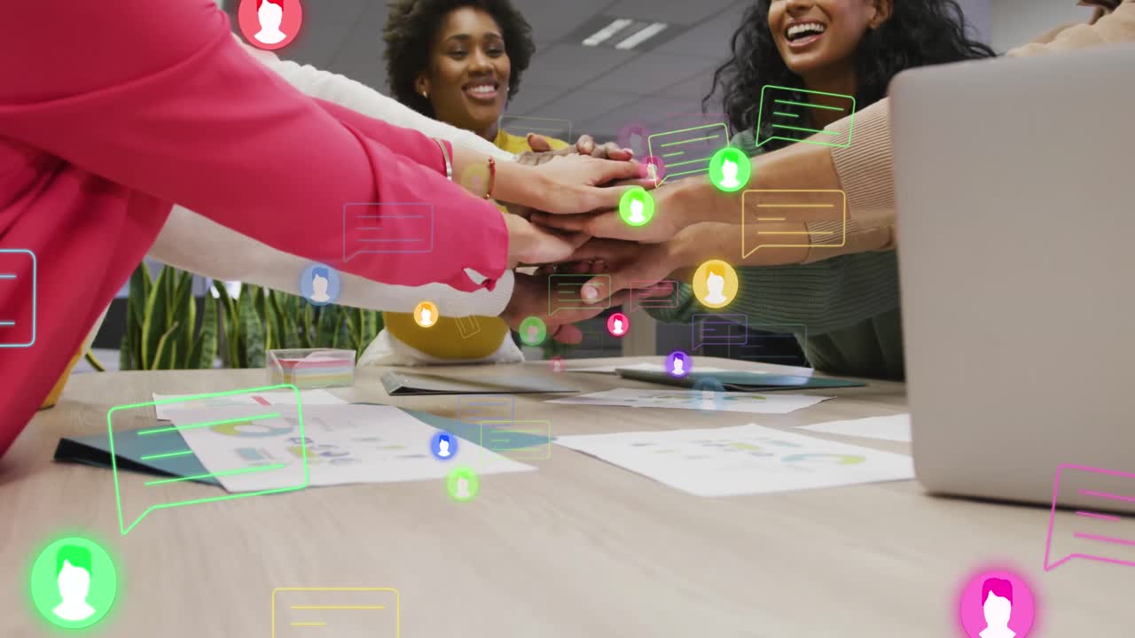 Animation of profile icons over team of diverse colleagues stacking their hands together at office
