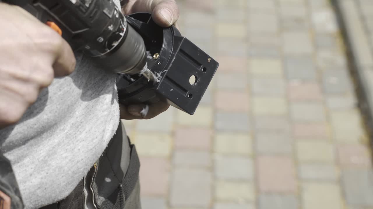 Drilling holes in a plastic case, close-up.