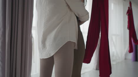Yoga instructor embraces partner during emotional moment as she stands barefoot on nail board inside calm studio, expressing support, mindfulness, and trust through healing connection