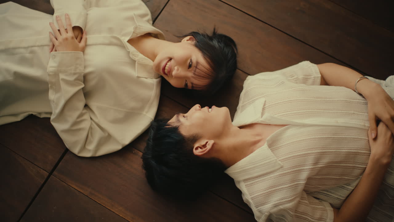 Couple Lying on Wooden Floor