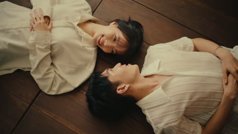 couple lying on wooden floor