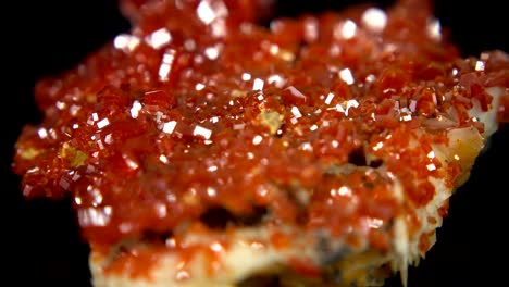 seamlessly rotating an orange mineral (vanadinite) in front of black background