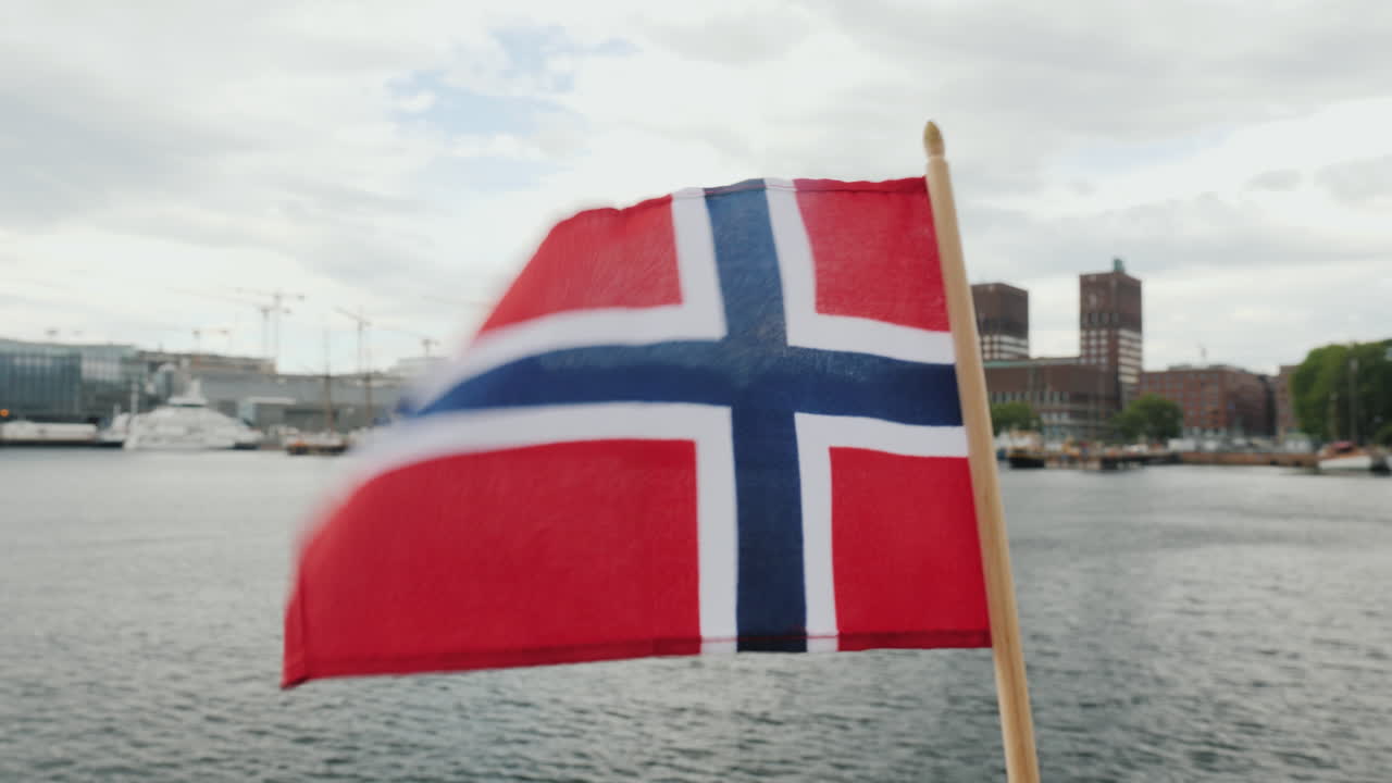 오슬로 스테디캠 샷의 도시 라인을 배경으로 노르웨이 국기와 함께 걷기