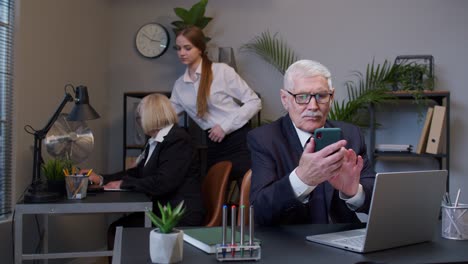 anciano empresario abuelo con teléfono móvil mensaje de texto trabajando viendo video comunicándose
