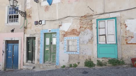 rustic facade with peeling paint and bright doors in lisbon portugal