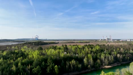 pine-tre-forest-with-coal-power-station-industry-at-distance-aerial-footage
