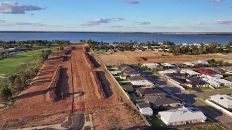 sobre nuevas casas y obras de tierra con el campo de golf black bull y el lago mulwala más allá