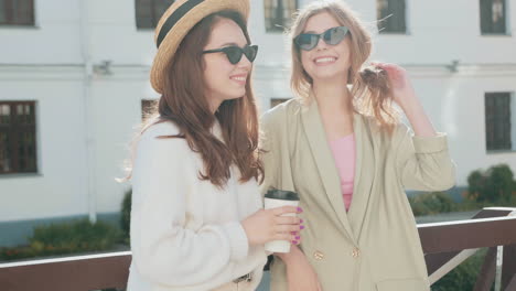 two young women friends enjoying coffee outdoors