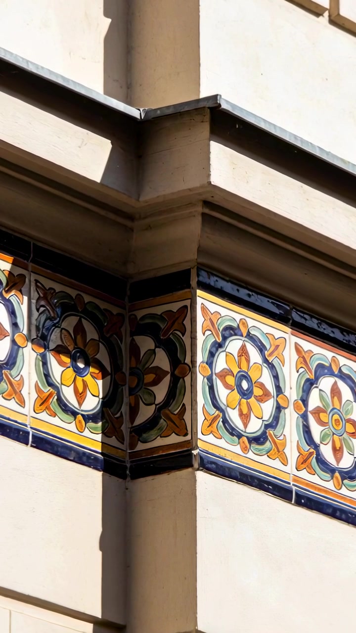 Video verticale: Telecamera che panoramica rivelando un angolo verticale sulla facciata di una strada per mostrare una fascia di piastrelle in ceramica.