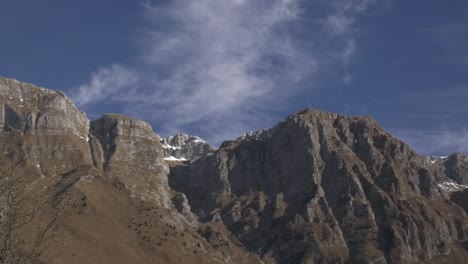 pan of mountain range on crisp clear cold winter day with blue sky and clouds