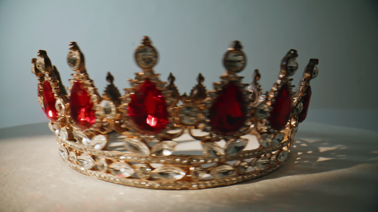 Macro noble crown rotating at white background. Decorated headpiece sparkling
