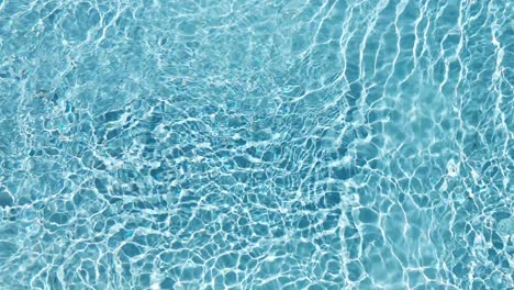 Water-surface-texture,-Slow-motion-clean-swimming-pool-ripples-and-wave,-Refraction-of-sunlight-top-view-texture-sea-side-white-sand,-sun-shine-water-background.-Water-Caustic-Background