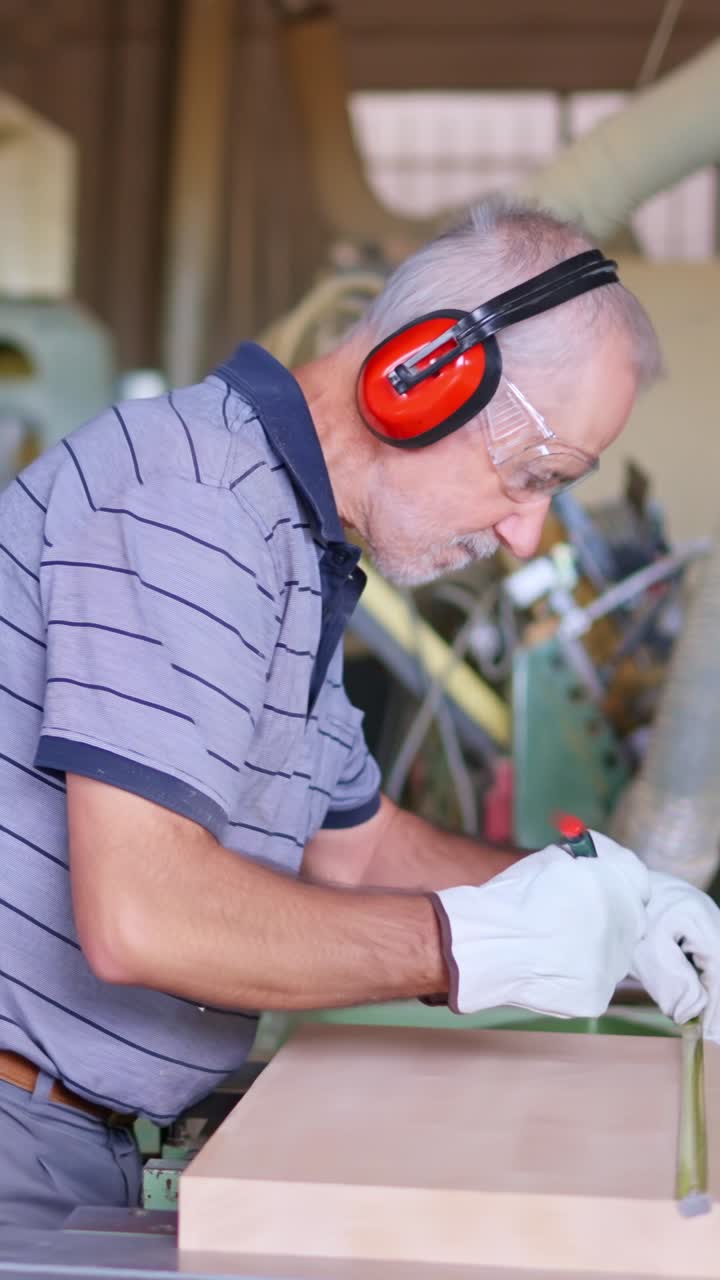Hombre con equipo de seguridad midiendo madera en un taller