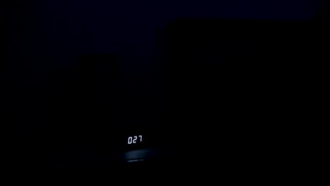 el joven se acuesta tarde en la noche y apaga la lámpara de la mesita de noche.