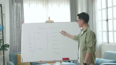 asian male teacher with glasses teaching english at home
