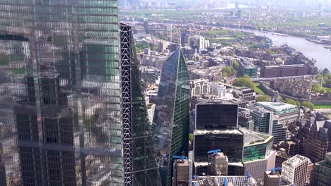 Close-aerial-view-of-the-City-of-London-towers-and-their-reflections-including-Bishopsgate,-Leadenhall-and-the-Gherkin-towers