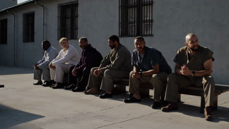 people sitting on benches in a prison courtyard