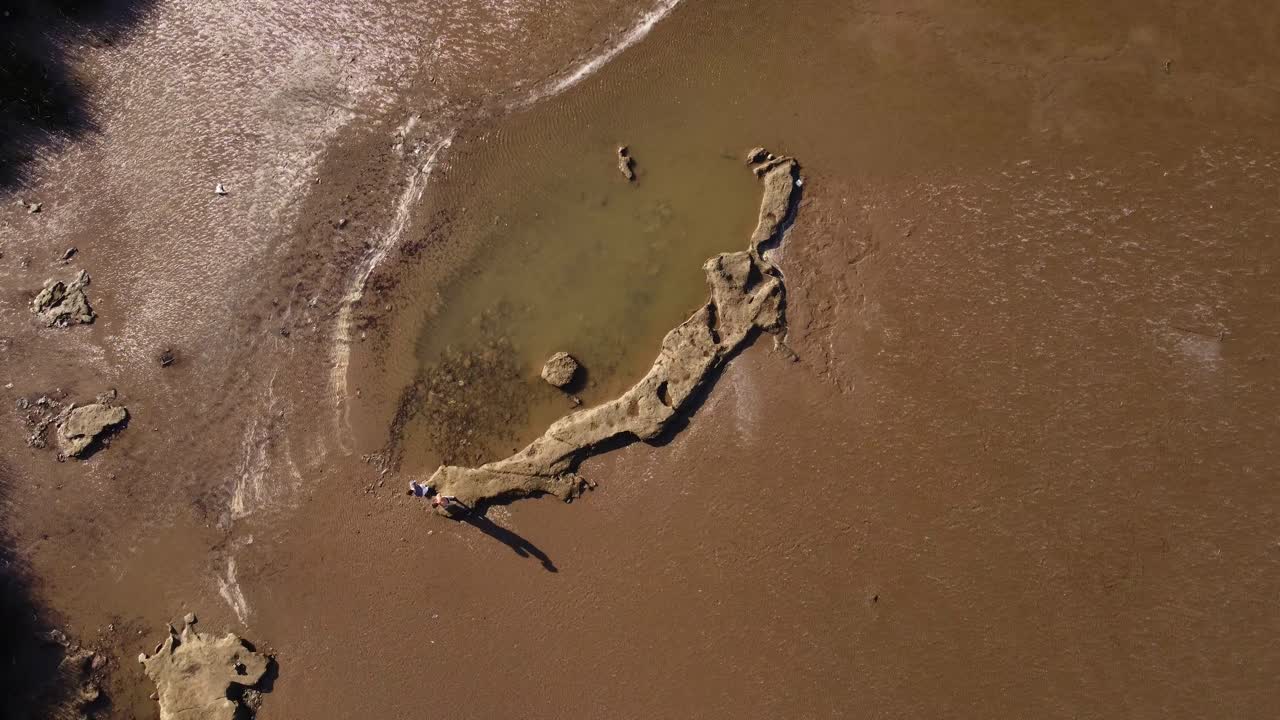 dos amigos caminando sobre rocas en el río de la plata, buenos aires