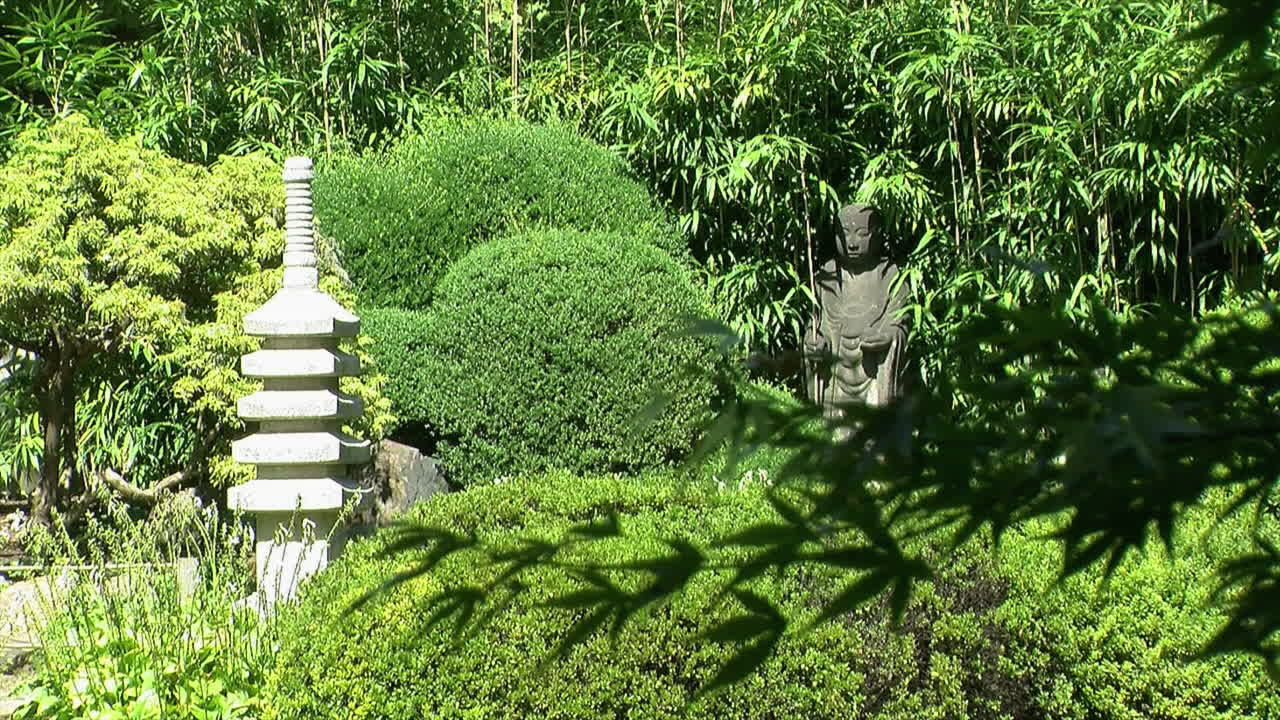 Stone pagoda and Buddhist statue of Jizo in a Japanese garden