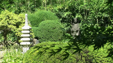 stone pagoda and buddhist statue of jizo in a japanese garden