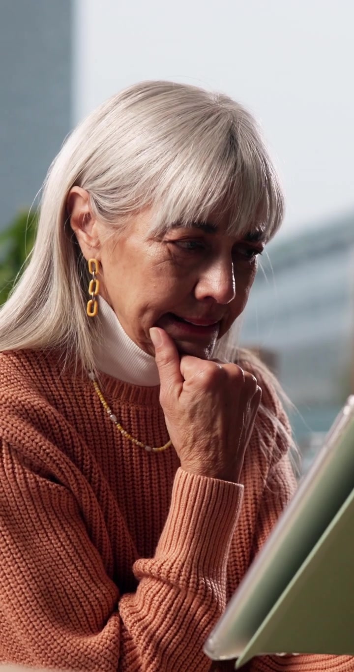 Senior Woman Using Tablet Computer in Bright Home Office