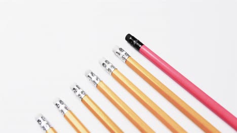 Close-up-of-pencils-arranged-on-white-background,-in-slow-motion