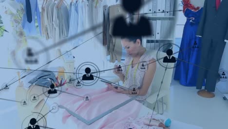 animation of network of profile icons over asian female fashion designer using tablet in a studio